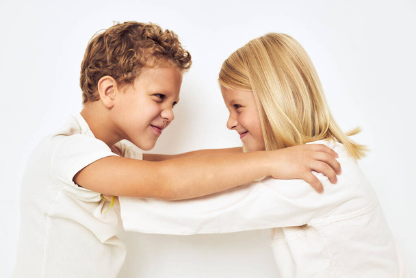 Kaksi lasta poika ja tyttö hymy poseeraa rento kulumista kevyt tausta - Valokuva, kuva