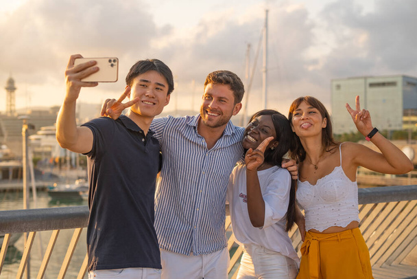 Gioioso multirazziale amici prendendo selfie su banchina - Foto, immagini