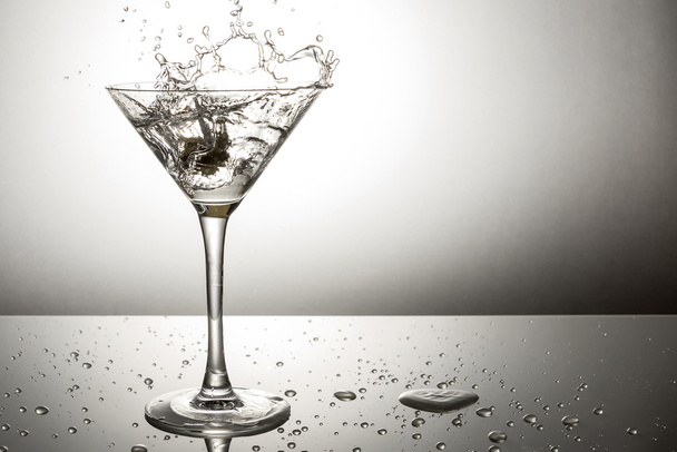 Olive splashing on martini - Фото, изображение