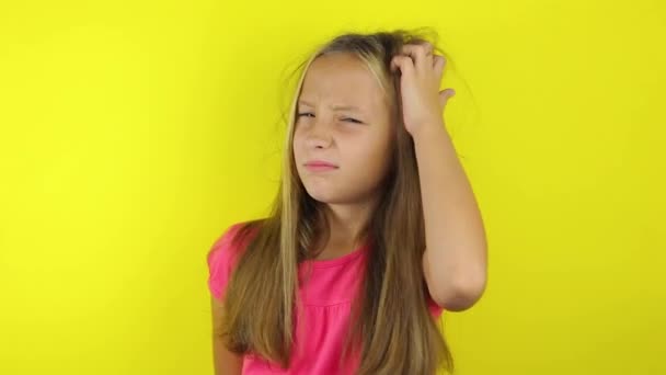 Dziewczyna drapie się po głowie na kolorowym tle - Materiał filmowy, wideo