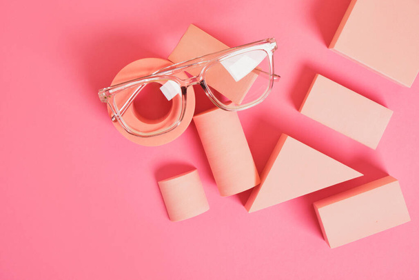 several different trendy eye glasses on geometric pink podiums, colorful background, copy space top view - Φωτογραφία, εικόνα