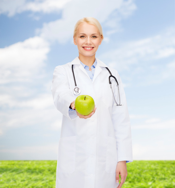 smiling female doctor with green apple - Zdjęcie, obraz