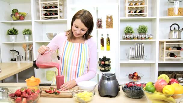 Valkoihoinen tyttö kaatamalla terveellisiä kotitekoisia hedelmiä smoothie
 - Materiaali, video