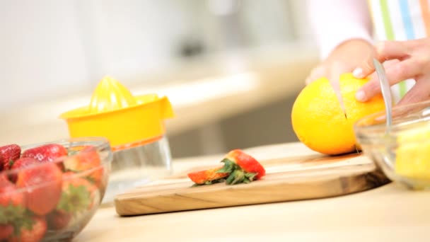κορίτσι στην κουζίνα προετοιμασία χυμό πορτοκαλιού - Πλάνα, βίντεο