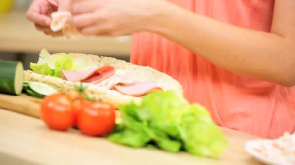 Chica en la cocina preparando sándwich submarino
 - Imágenes, Vídeo