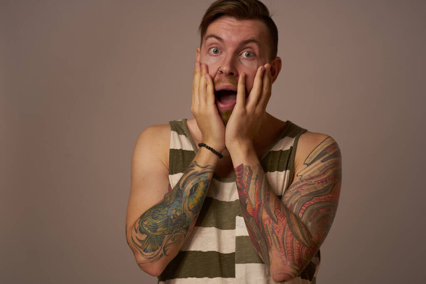 handsome man with tattoos on his arms fashionable hairstyle emotions - 写真・画像