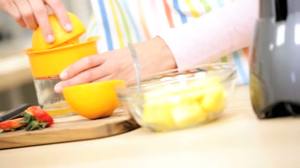 κορίτσι στην κουζίνα προετοιμασία χυμό πορτοκαλιού - Πλάνα, βίντεο