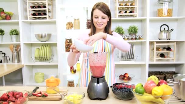 υγιή καυκάσιος κορίτσι κάνοντας φρέσκα φρούτα smoothie - Πλάνα, βίντεο