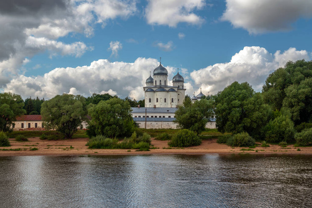 View of the St. George's Cathedral of the St. George (Yuriev) Monastery from the Volkhov River on a sunny summer day with cumulus clouds, Veliky Novgorod, Russia - Photo, image