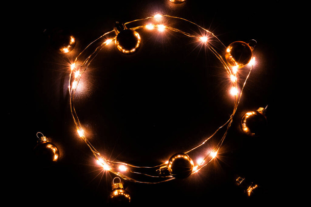 Luzes de Natal na fronteira. Decoração de grinalda luz dourada, bulbo de ouro isolado no preto para decoração de ornamento de festa de xmas fundo. Luzes brilhantes para férias de Natal - Foto, Imagem