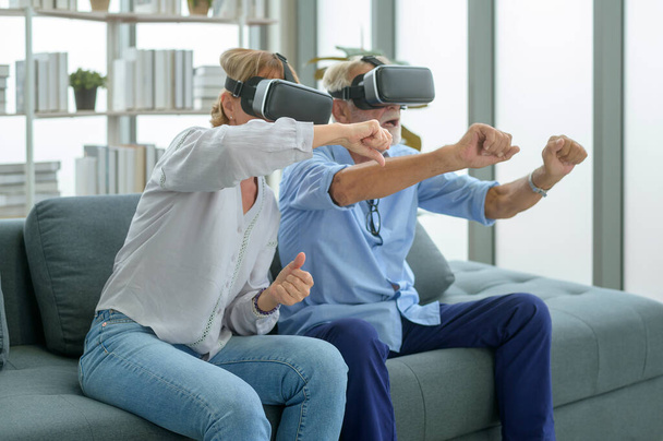 A Caucasian senior couple wearing vr box at home - Foto, afbeelding