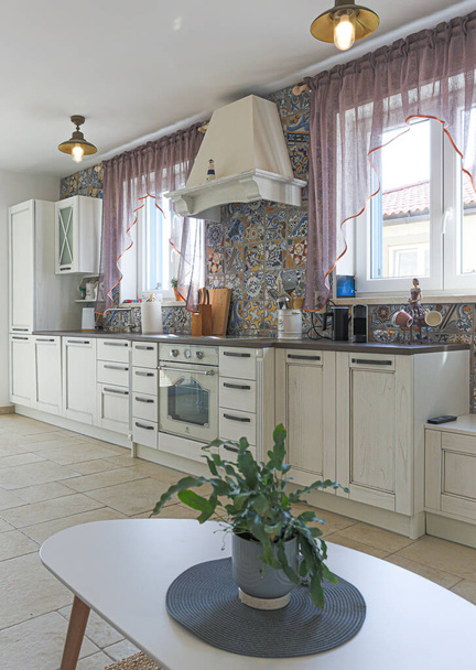 白いキャビネットとカラフルなタイルの古典的な現代的なスタイルの広々としたキッチン - 写真・画像