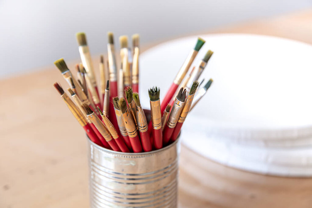 Close-up of red paint brushes in a metal jar. - Photo, Image