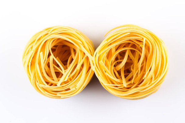 Fettuccine pasta nest isolated on white background - Фото, изображение