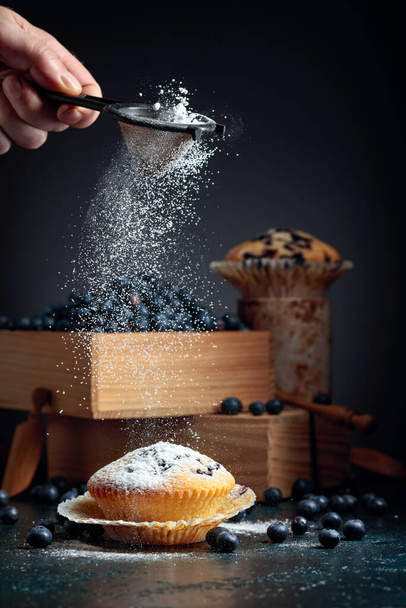 Muffins aux myrtilles et baies dans une boîte en bois. Muffins saupoudrés de sucre en poudre. - Photo, image