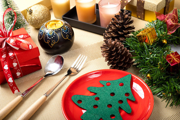 Een Kerst eettafel instelling met een helder rode keramische bord. - Foto, afbeelding