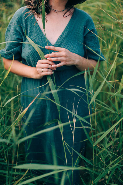 portrait of a girl in a blue dress in a summer green field with grass, beautiful summer authentic lifestyle - Photo, image