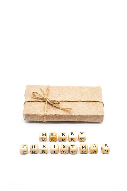 Joyeux Noël mots fabriqués à partir de cubes en bois, boîtes-cadeaux enveloppé papier brun artisanat. Style minimaliste, pose plate. - Photo, image