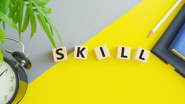 Holzblöcke mit der Aufschrift Skill auf gelbem Hintergrund. Bildung und Geschäftskonzept - Foto, Bild
