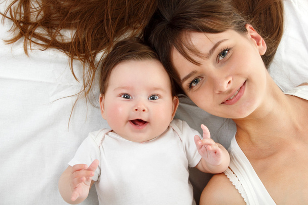 Mother with cute smiling baby lying - Foto, imagen