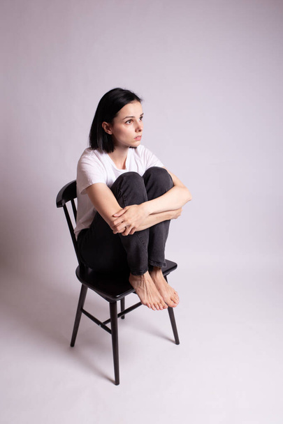 girl in a white t-shirt sits on a chair in the studio - Foto, immagini