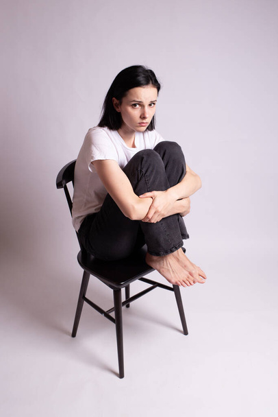 girl in a white t-shirt sits on a chair in the studio - Foto, Imagem