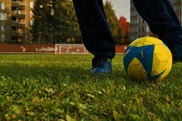 Гравець грає в футбол на зеленому полі трави і б "є м" яч.. - Фото, зображення