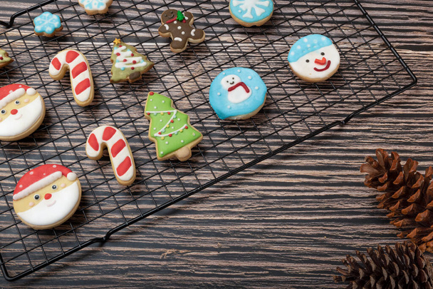 Biscoitos revestidos de açúcar e biscoitos temáticos de Natal em uma cremalheira com ornamentos de Natal. - Foto, Imagem