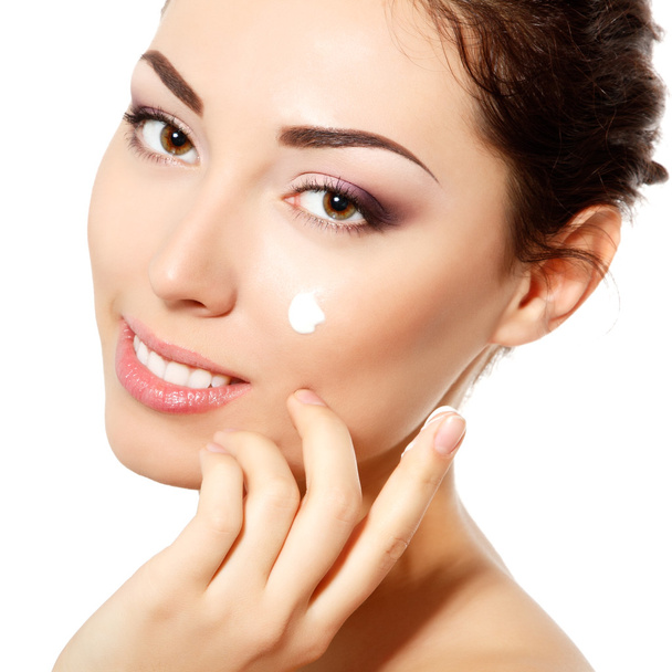 Young woman applying ceam on face - Foto, Imagem