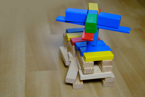colored wooden cubes, builds houses and rockets, the concept of the development of creativity, fine motor skills, patience and perseverance - Photo, image
