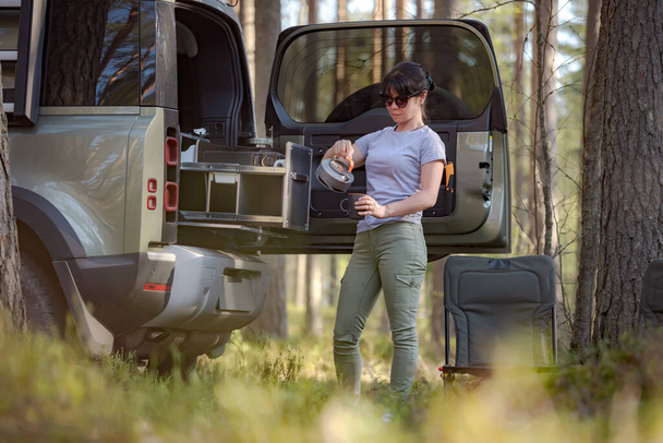Trip in the nature by car family vacation on the weekend. Woman traveller enjoy coffee time. - Foto, Imagen