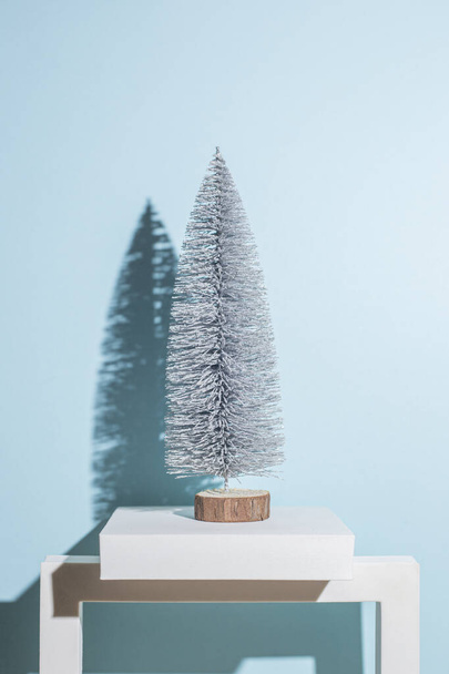 Dekoratív karácsonyfa kék háttérrel. Kemény árnyékok. - Fotó, kép