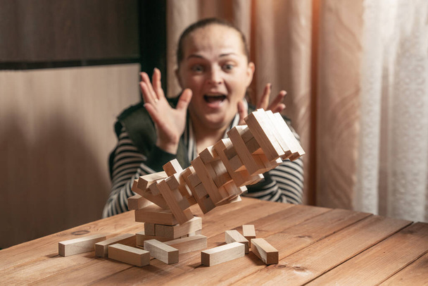 Mom and daughter play a board game, build a tower from wooden blocks. - Foto, imagen