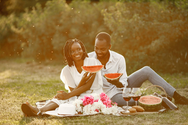 African american couple with watermelon on a meadow - Фото, зображення