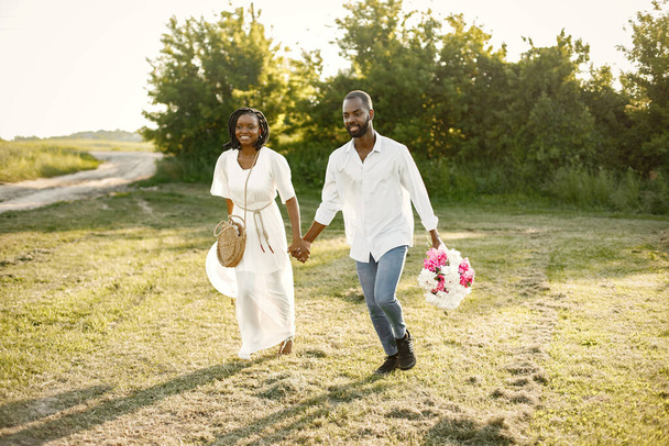 African newlyweds walking with bouquet in nature - Zdjęcie, obraz