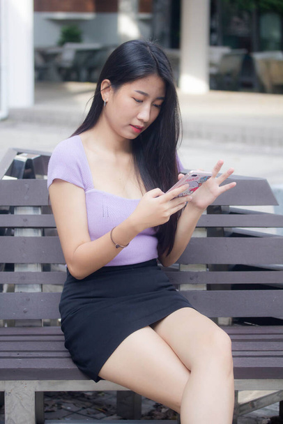 portrait of thai adult office girl using her phone and smile - Фото, изображение