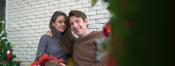 Happy white caucasian couple exchange gifts on Christmas morning - Photo, Image