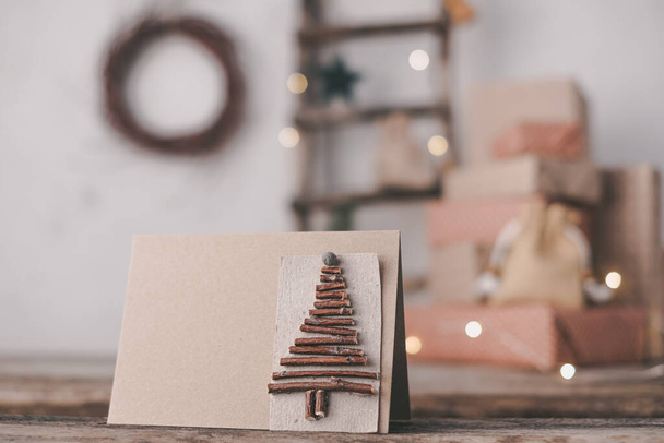Close-up creatieve duurzame eco kerstboom handgemaakt van houten takken op de achtergrond geschenkdozen. Geen afval Kerstconcept - Foto, afbeelding