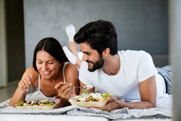Romantic happy couple having breakfast in bed. Love, people, food concept - Foto, immagini