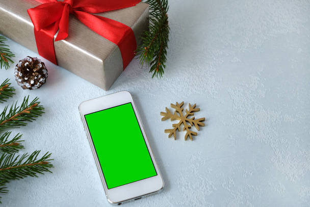 Christmas online shopping.Order gifts from smartphone with copy space. Green screen, chroma key.Concept: advertising, presents for xmas, winter holidays sales.Selective focus - Foto, Imagem