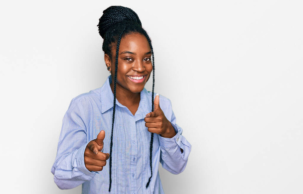 若いアフリカ系アメリカ人の女性は、楽しそうにカメラに指を指してカジュアルな服を着ています。良いエネルギーと振動は.  - 写真・画像