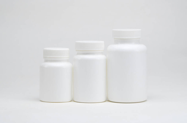 White plastic pill jars on a white background. Isolated - Φωτογραφία, εικόνα