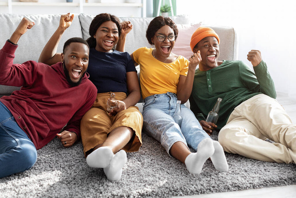 Ευτυχισμένοι μαύροι νέοι που απολαμβάνουν το ποδόσφαιρο στο σπίτι - Φωτογραφία, εικόνα