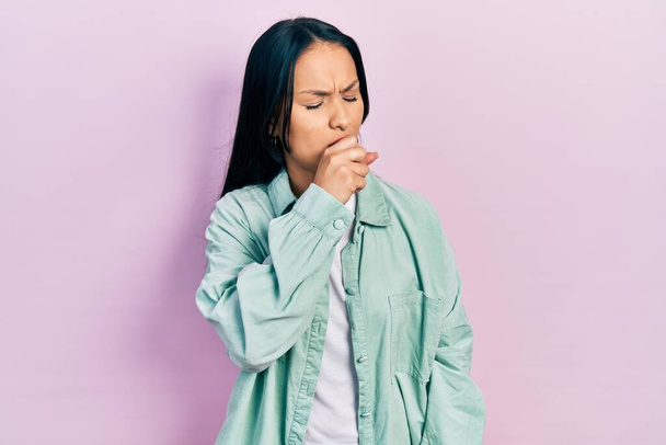 Schöne hispanische Frau mit Nasenpiercing in lässiger grüner Jacke fühlt sich unwohl und hustet als Symptom für Erkältung oder Bronchitis. Gesundheitskonzept.  - Foto, Bild