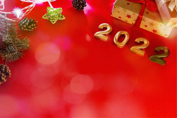 Flat lay format greeting card happy new year, numbers 2022 and gifts on red background with bokeh. - Photo, Image