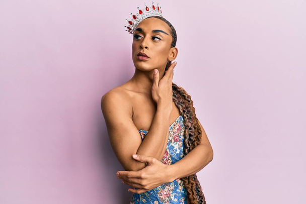 Sensuale ispanica transgender donna indossa regina corona e posa glamour con viso seducente indossa lingerie sexy - Foto, immagini