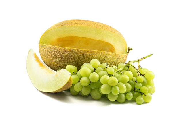 frische gelbe Melone mit einer Scheibe und Trauben isoliert über weiß - Foto, Bild