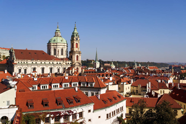 PRAGUE, CZECH REPUBLIC - OCTOBER 10, 2021: Mala Strana roofs and St. Nicholas Church in autumn - Zdjęcie, obraz
