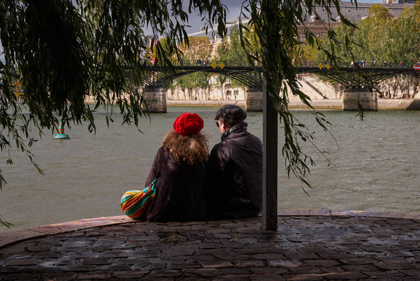 Meydan du Vert Galant 'ın ucunda oturan yetişkin çift - Paris, Fransa - Romantizm, Kızıl Bereli Kadın, Klasik - Fotoğraf, Görsel