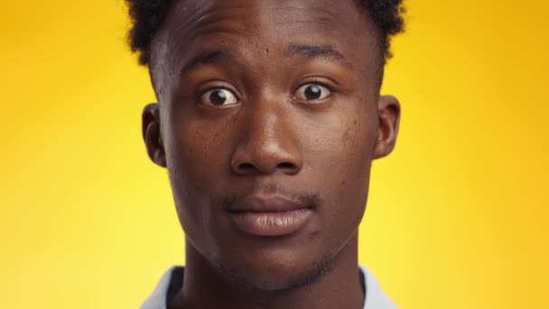 Reazione agli urti. Giovane uomo afroamericano stordito aprire gli occhi ampiamente stupito, guardando la fotocamera - Filmati, video